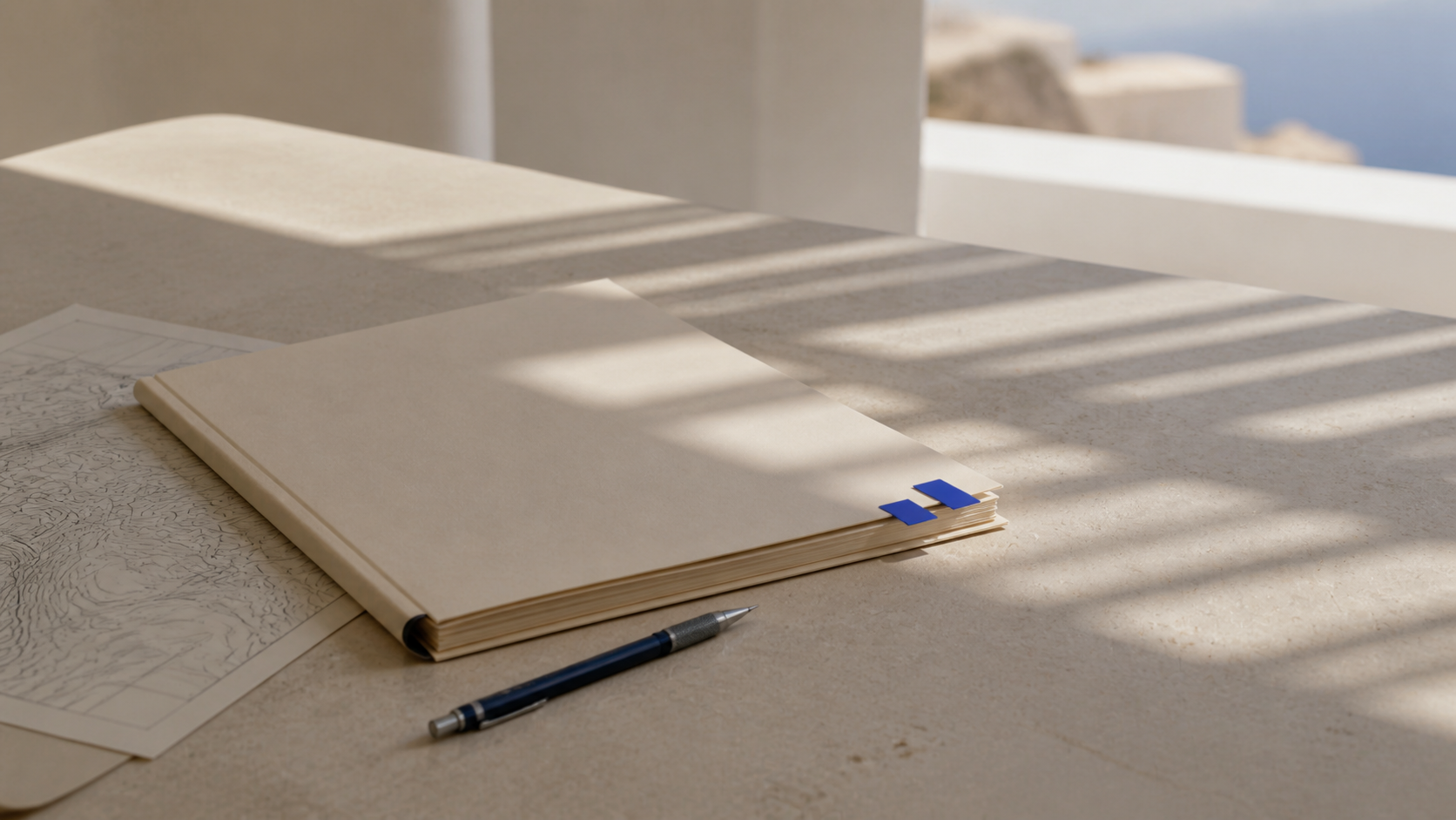 Carnet et carte sur une terrasse en pierre avec vue sur la mer Égée